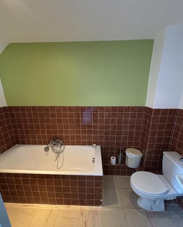 Bathroom with bath and tiled walls